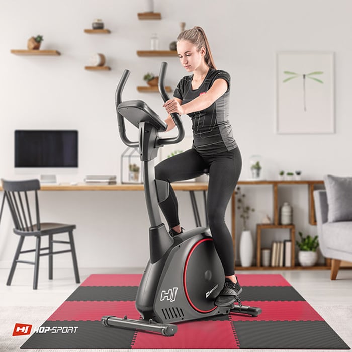 Chica haciendo ejercicio en equipo de fitness sobre la esterilla puzzle negro-rojo de 2cm 12 piezas