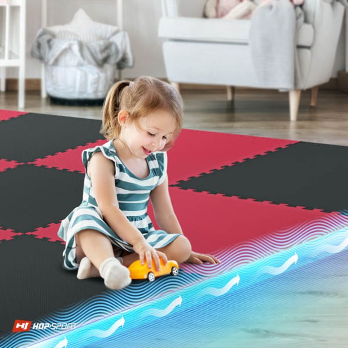 Niño sentado en la esterilla puzzle negro-rojo Hop-Sport de 2cm 12 piezas