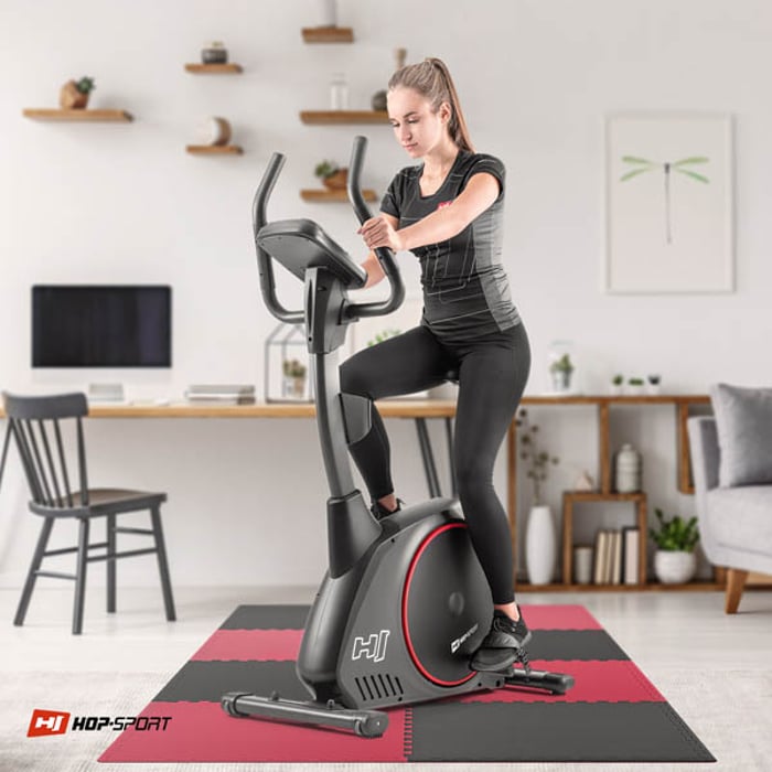 Chica haciendo ejercicio en equipo de fitness sobre la estera puzzle negro-rojo 2cm 8 piezas