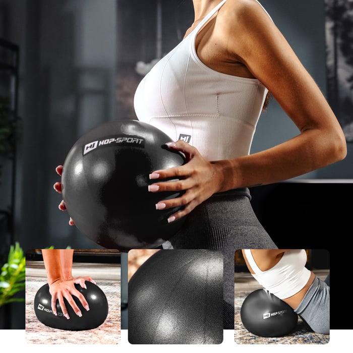 Modelo ejercitándose con una pelota negra de pilates Hop-Sport