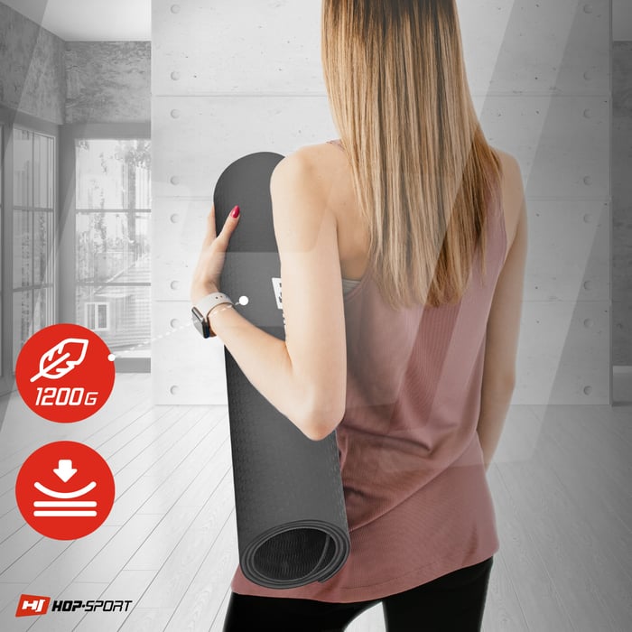 Chica sosteniendo la esterilla TPE enrollada 0,8cm en color negro-rojo de la marca Hop-sport