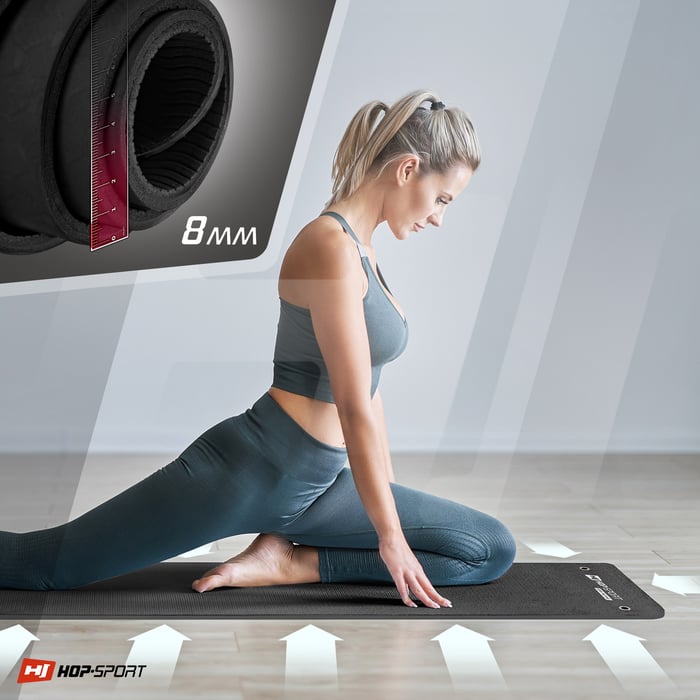 Chica ejercitándose en la esterilla TPE con agujeros para colgar en color negro-rojo de la marca Hop-sport