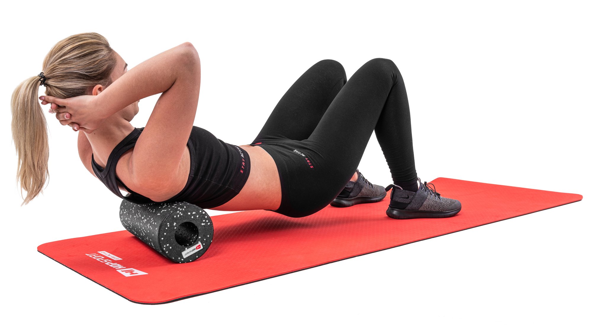 Mujer rodando los músculos de la espalda con un rodillo de 33cm negro con puntos blancos